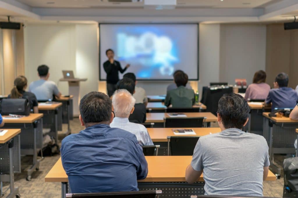 Audiences sitting and listening to the speakers at a conference